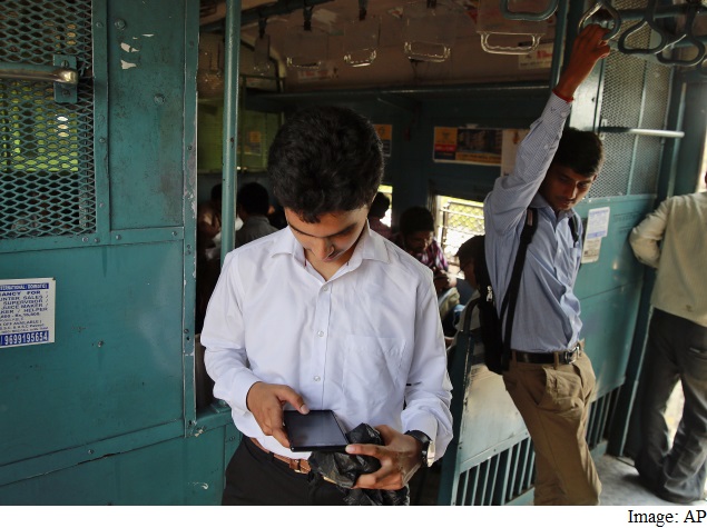 man_checking_mobile_on_train_india_ap.jpg